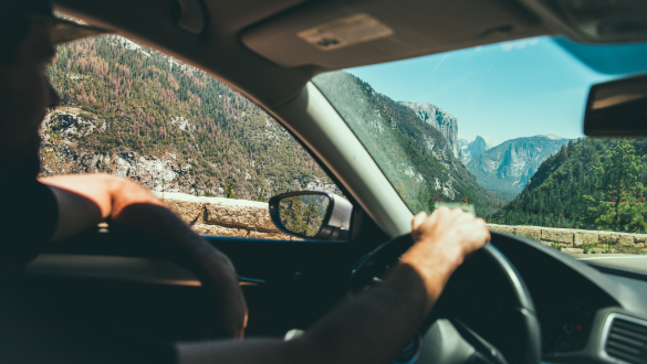Mann fährt ein E-Auto, Roadtrip durch die Berge, Elektroauto
